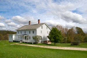 A white wooden farmhouse in a rural setting.