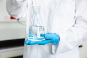Laboratory specialist holding a water sample for contaminant testing
