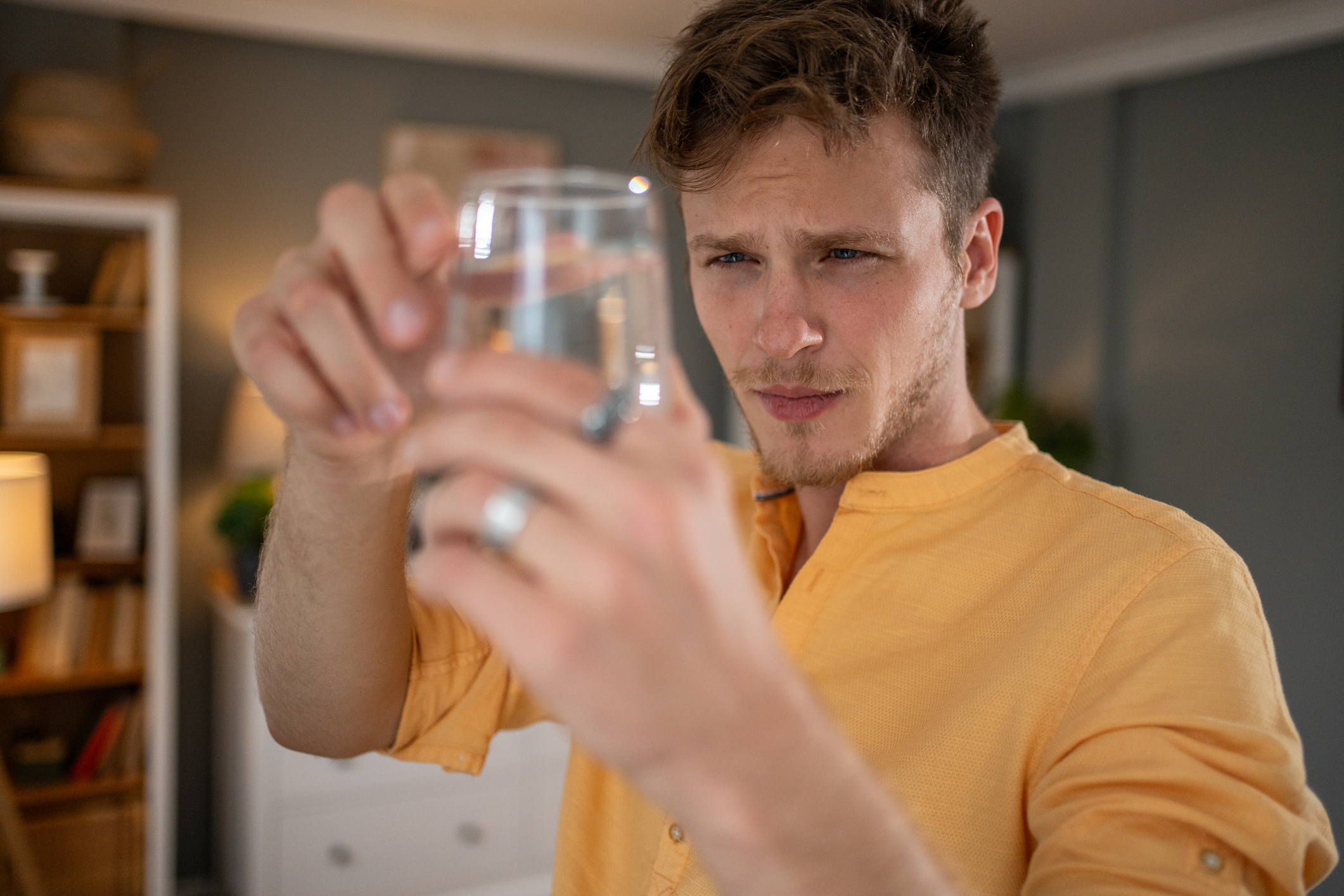 Carefully inspecting a glass of water for potential contamination